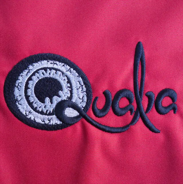 Haft logo Quaba — ścieg łańcuszkowy na czerwonym materiale