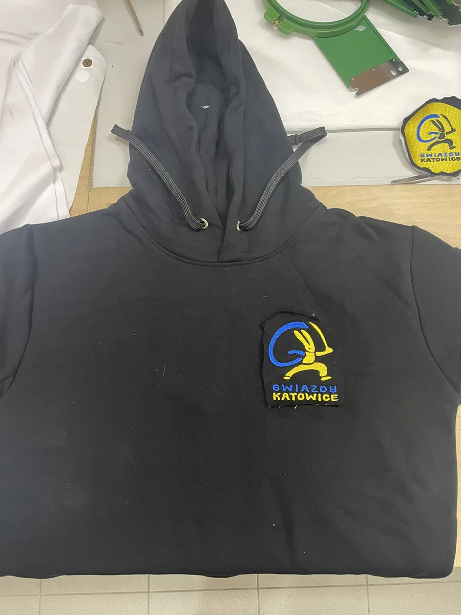Czarna bluza z kapturem z haftowanym logo klubu sportowego na piersi