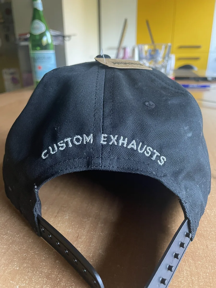 Płaski haftowany napis Custom Exhausts z tyłu granatowej czapki z daszkiem