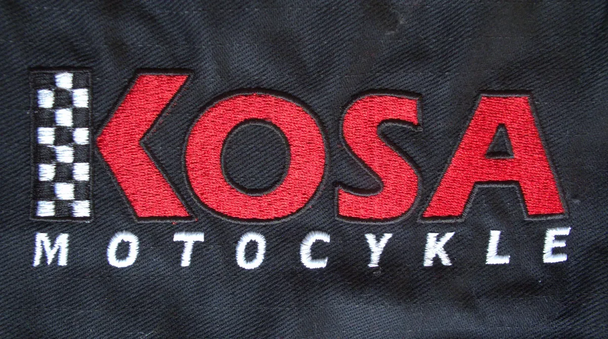 Haftowane logo firmy motocyklowej w czerwono-białej kolorystyce